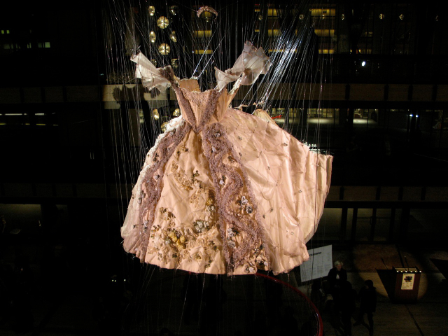 
                            <h4><em>Cinderella</em></h4>
                            2009 / 2010 
                            <br /><br />
                            Mixed media (made with costumes from the 
							<br />New York 
							City Opera archives)
                            </br>
                            Approx.10 x 6 feet in diameter 
                            <br /><br />
                            This sculpture is composed of two Cinderella dresses that symbolize her transformation: the white, cake-like Princess 
                            dress with its pearls and panniers, and a dress found on a rack of the costume archive labeled Distressed Peasant. 
                            Ironically, the peasant dress is more a marvel of handiwork and artificeits luscious cashmere woven to look like burlap, 
                            its hand-made lace hand-torn and rubbed with ink to look sooty, and its silk velvet corselette punched with holes. 
                            The bloated, regal Princess dress splits down the back, and the cicada-like, deluxe dishevelment erupts.
                            